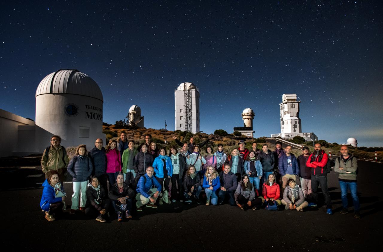 Teachers during night time observation with the solar towers at background