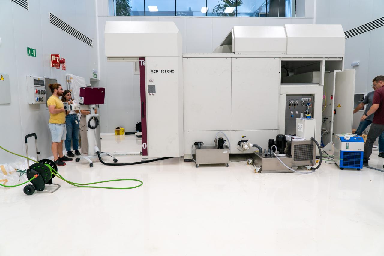 Tres ingenieras probando una máquina de gran envergadura en una sala blanca (sala limpia sur de IACTEC)