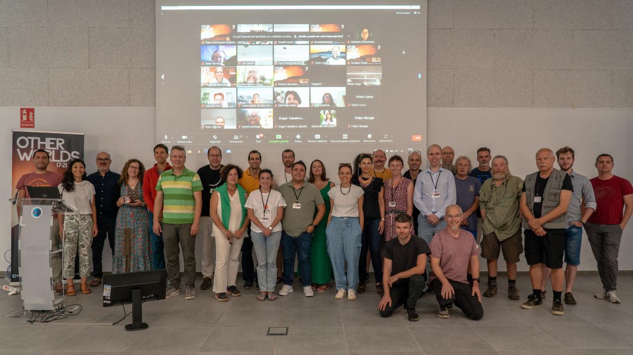 Foto de grupo con los ponentes, los participantes presenciales y los participantes en modo telemático