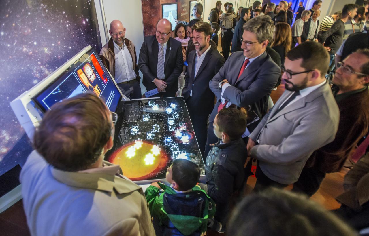 El director del IAC, Rafael Rebolo, el presidente del Cabildo de Tenerife, Carlos Alonso, el director de la ACIISI, Juan Ruiz Alzola, y el Director General de Cultura del Gobierno de Canarias, Xerach Gutiérrez Ortega, con los comisarios de la exposición "Luces del Universo" y público general en el módulo sobre "Hitos científicos del IAC".