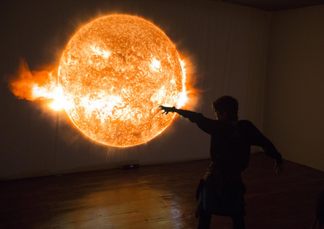 Un niño jugando ante el módulo interactivo “Inmersión solar” de la exposición “Luces del Universo”. Créditos: Daniel López/IAC. 
