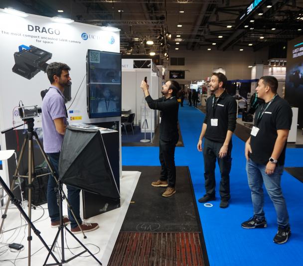 Visitors taking pictures of the image on screen at the IACTEC stand.