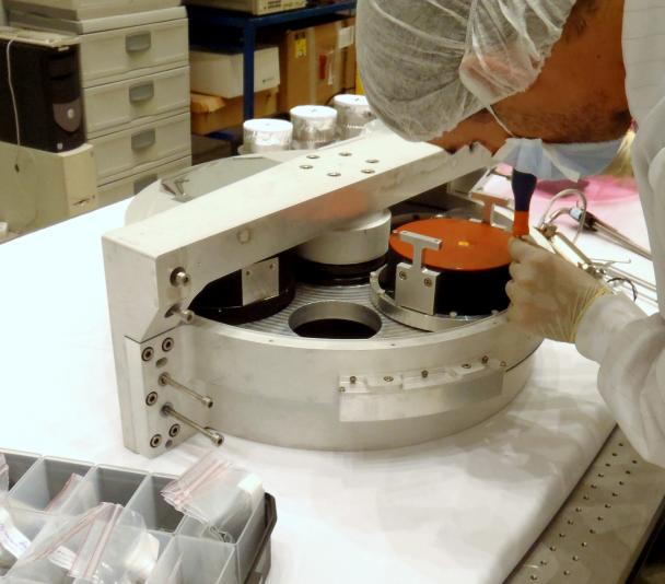 Vista de un ingeniero trabajando en la rueda de grismas del instrumento EMIR en el laboratorio