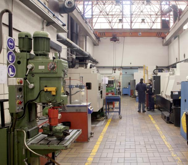 Vista de una parte del taller de mecánica con técnicos en una máquina