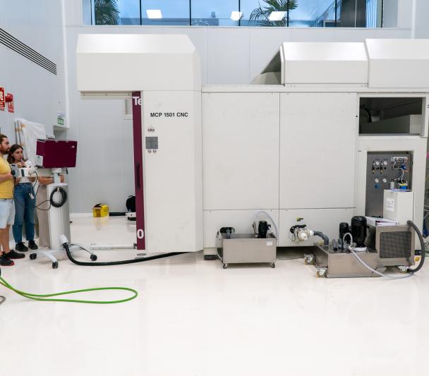 Tres ingenieras probando una máquina de gran envergadura en una sala blanca (sala limpia sur de IACTEC)
