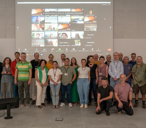 Foto de grupo con los ponentes, los participantes presenciales y los participantes en modo telemático