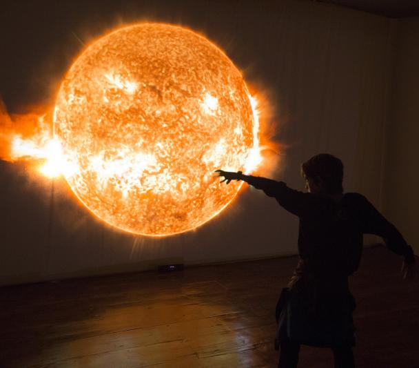 Un niño jugando ante el módulo interactivo “Inmersión solar” de la exposición “Luces del Universo”. Créditos: Daniel López/IAC. 