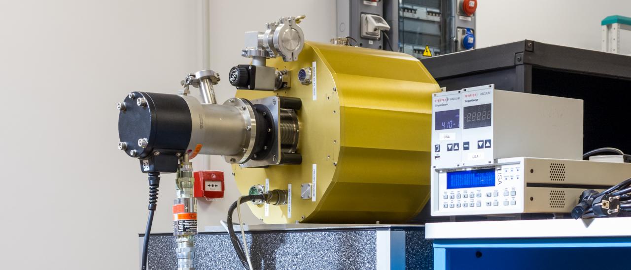 Part of equipment used for the characterization of astronomical detectors. Metallic cylinder on a table coupled to a small chiller and to a vacuum pump