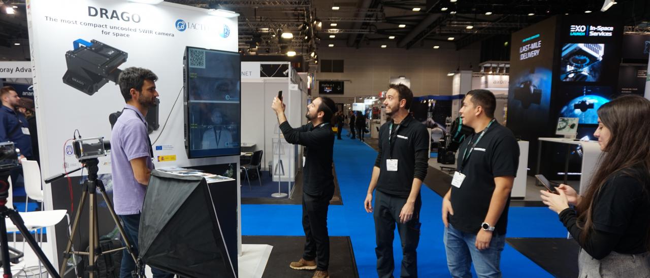 Visitors taking pictures of the image on screen at the IACTEC stand.