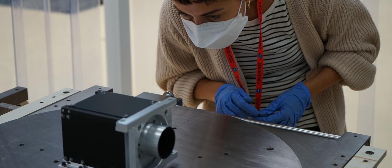 Imagen de Alba Peláez, ingeniera de IACTEC, durante la puesta a punto del montaje de pruebas para la medida del centro de gravedad del instrumento DRAGO