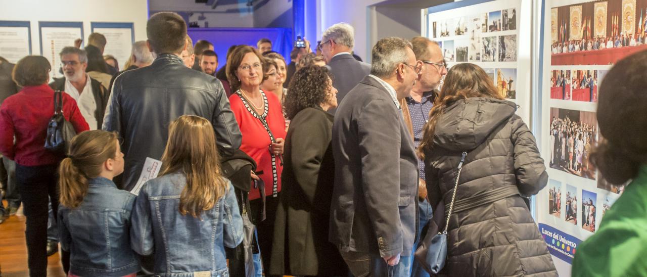 Visitors to the "Lights of the Universe" exhibition studying the panels dedicated to the history of the IAC and its observatories. Credits: Daniel López/IAC 