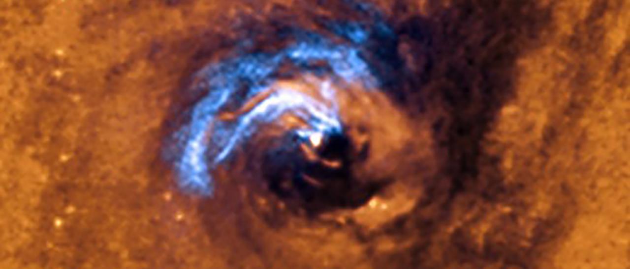 La imagen muestra el proceso de alimentación nuclear de un agujero negro en la galaxia NGC 1566 y cómo los filamentos de polvo que envuelven el núcleo activo quedan atrapados y giran en espiral alrededor del agujero negro hasta que son tragados por él. Crédito: Observatorio Europeo Austral (ESO).