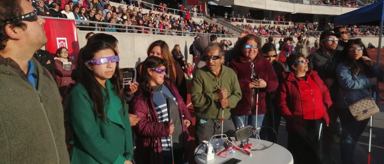 A group of people with visual impairments experiencing a total solar eclipse 