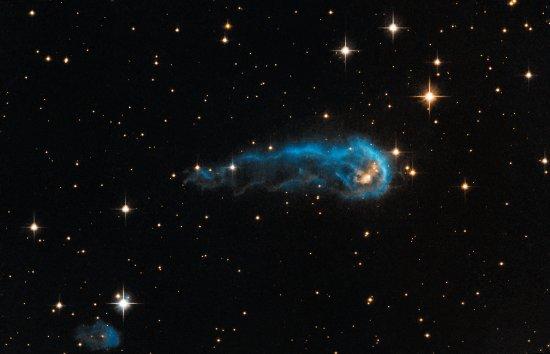 Protostar IRAS 20324+4057. The matter ejected from the protostellar envelope is revealed in the image in the shape of a blue comet or caterpillar. The protostar itself and the dense envelope of dust and gas that surrounds it - the so-called cocoon - are e