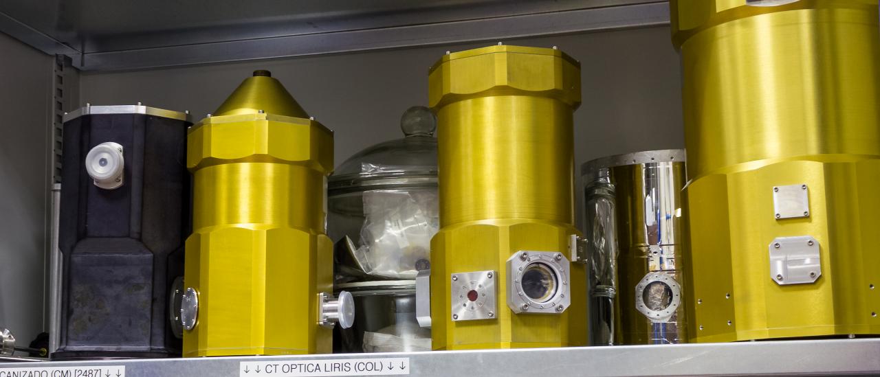 General view of several test cryostats in a laboratory cabinet. Shelves of a cabinet with different metal cylinders fitted with windows and connectors