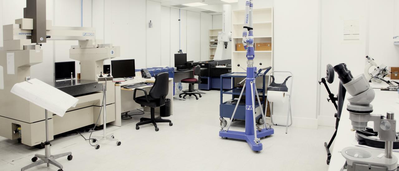 Vista general del laboratorio de metrología dimensional con varias máquinas de medir, una de tipo puente sobre una mesa y otra en forma de brazo sobre un trípode