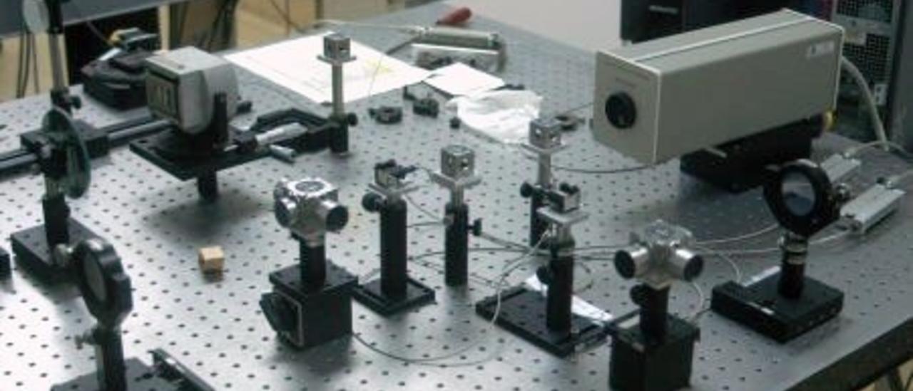 Vista del interferómetro en el laboratorio. Pequeños dispositivos ópticos y electrónicos alineados en forma de cruz en una mesa de laboratorio