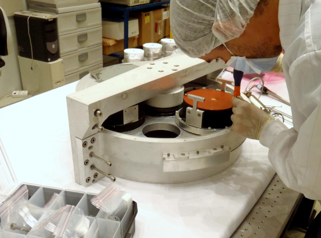 Vista de un ingeniero trabajando en la rueda de grismas del instrumento EMIR en el laboratorio