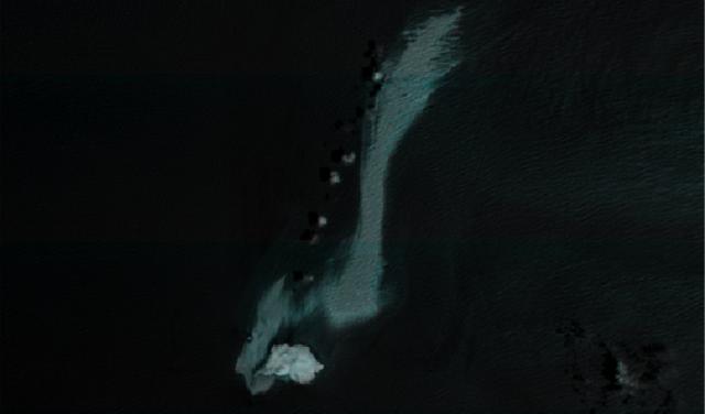 False-colour satellite image of the Arabian Sea showing an extensive light-coloured oil slick next to the Caroline Bezengi tanker and near an island in Oman’s Al Hallaniyat archipelago.