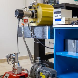 Part of equipment used for the characterization of astronomical detectors. Metallic cylinder on a table coupled to a small chiller and to a vacuum pump