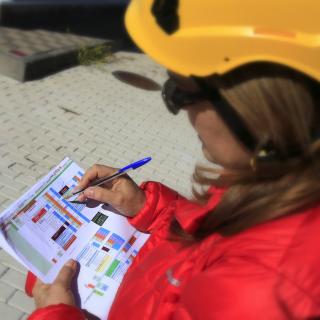 Engineer managing the installation phase of the EMIR instrument. Author D. López. View of a woman engineer reviewing some graphs on paper