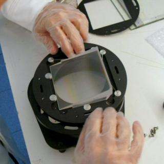 View of an engineer assembling a grism in the laboratory View of an engineer assembling a grism in the laboratory. Engineer placing a piece of glass in a metal cylinder