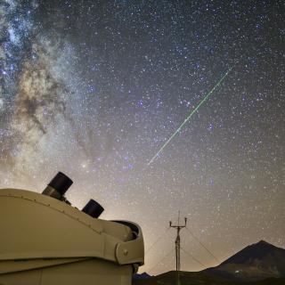 Una perseida cruza el cielo sobre el volcán Teide, la noche del 11 al 12 de agosto de 2020, bajo la atenta mirada del telescopio MASTER. En la imagen, tomada desde el Observatorio del Teide (Instituto de Astrofísica de Canarias), también se puede ver el centro galáctico. Autor: D. Padrón. (Descarga en alta resolución: https://flic.kr/p/2jvWE3A)