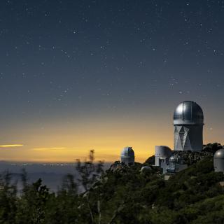 A view of the Mayall Telescope (tallest telescope at right) at Kitt Peak National Observatory near Tucson, Arizona. (Credit: Marilyn Chung/Berkeley Lab)