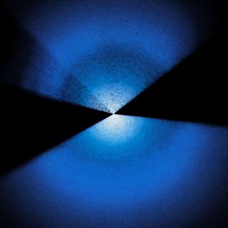 Two fans of blue and white dots extending up and down from center on a black background