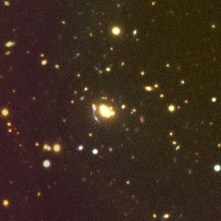 Imagen RGB de PSZ1 G158.34-47.49, uno de los cúmulos estudiados, ubicado a un desplazamiento al rojo de z=0,311 (espectroscópico). En la imagen puede apreciarse un arco gravitatorio. La imagen fotométrica se obtuvo con ACAM/WHT; los datos espectroscópicos, con DOLORES/TNG.