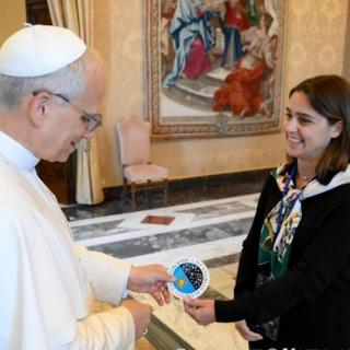 Imagen del momento en el que los doctorandos del IAC Stella Tsilia y Jun-Yan Zhang (Jerry) entregan al Papa León XIV la pegatina con el logo del IAC Imagen del momento en el que los doctorandos del IAC Stella Tsilia y Jun-Yan Zhang (Jerry) entregan al Papa León XIV la pegatina con el logo del IAC