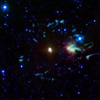 Imagen de la nebulosa planetaria Ojo de Gato compuesta mediante los datos obtenidos por la cámara infrarroja del telescopio espacial Spitzer. En general, los colores se han mejorado para mostrar ligeras variaciones en el tono. La emisión infrarroja de est 8085