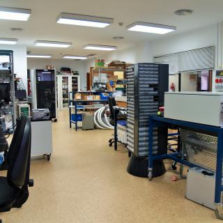 General view of the electronic design laboratory with several workbenches, electronic racks and cabinets for components and electronic parts