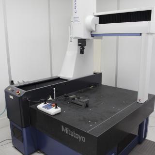 Vista de una máquina de medida de 3 coordenadas en el laboratorio. Mesa de granito con una máquina en forma de pórtico con un sensor medidor