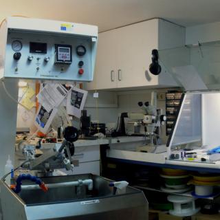 Vista panorámica del laboratorio de fibras ópticas Vista panorámica del laboratorio de fibras ópticas. A la izquierda, máquina para colocar los materiales a pulir con mandos de control en la parte superior y a la derecha, mesas de trabajo con campanas extractoras de gases