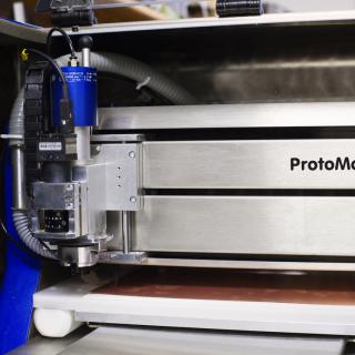 Detail of the front view of the PCB plotter. Metal front end and head with cables similar to a printer