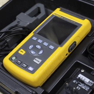 View of the FLUKE analyser in its transport case View of the FLUKE analyser in its transport case. Portable rugged device with buttons and a small screen placed in its carrying case